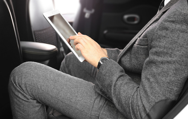 Businessman with tablet in a car - Foto, imagen