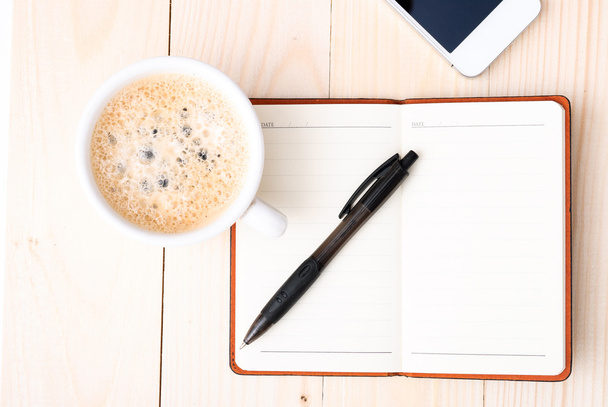 Smartphone with notebook and cup of strong coffee - Photo, Image