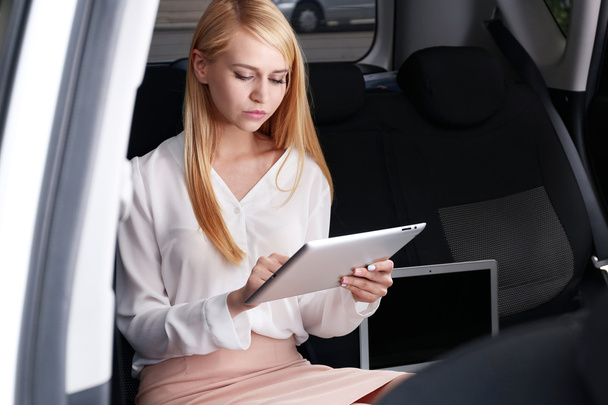 Businesswoman with tablet in a car - Фото, зображення