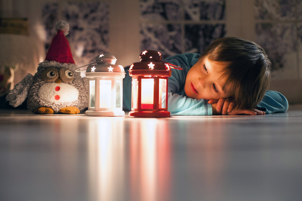 Beautiful little boy, lying down on the floor, looking at candle - Φωτογραφία, εικόνα