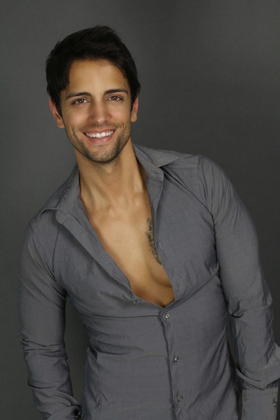 Handsome man wearing a gray shirt smiling - Foto, Bild