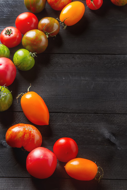 Colorful ripe tomatoes. Delicious vegetarian food. Dark backgrou - Foto, imagen