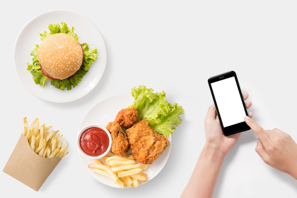 Design concept of mockup Using smartphone with burger, french fries. - Foto, Imagem