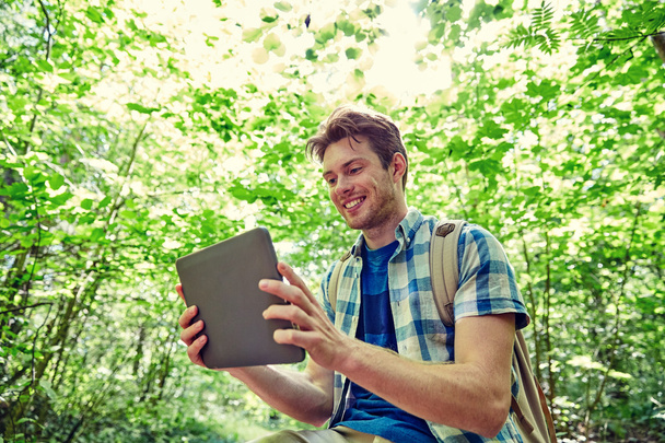 happy man with backpack and tablet pc in woods - Fotoğraf, Görsel