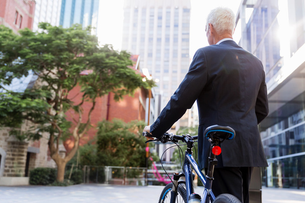 Successful businessman riding bicycle - Foto, imagen