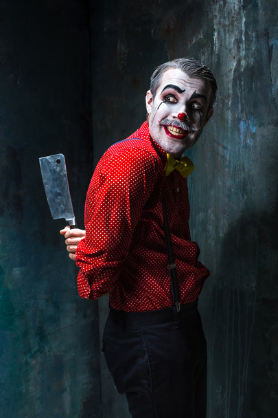 The crazy clown holding a knife on dack. Halloween concept - Zdjęcie, obraz