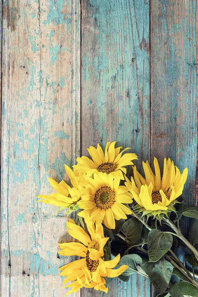 Background with a bouquet of yellow sunflowers on old wooden boa - Фото, зображення
