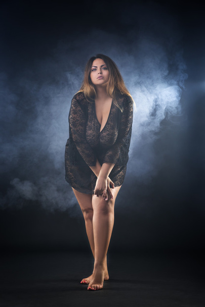 Young naked beautiful caucasian plus size model, xxl woman in black peignoir on smoky background, beauty female nude body with big breast - Fotoğraf, Görsel