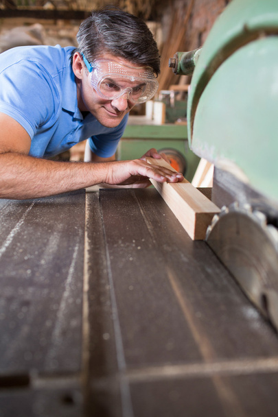 Carpintero cortando madera en sierra circular
 - Foto, Imagen