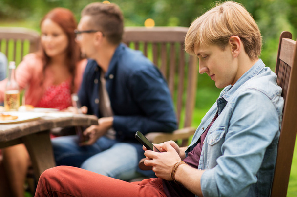 man with smartphone and friends at summer party - Photo, Image