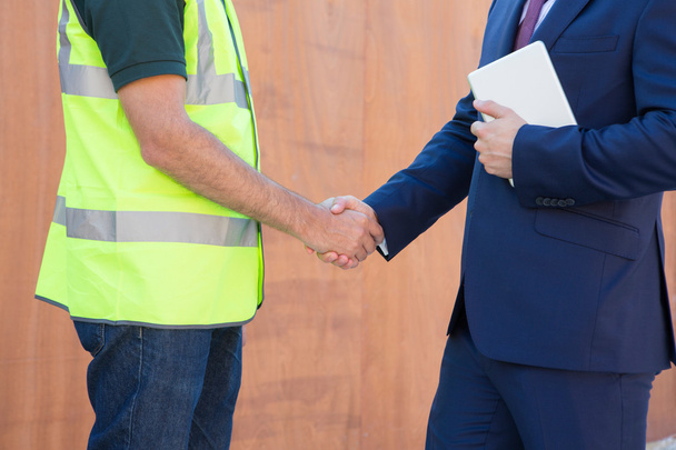 Businessman Shaking Hands With Builder On Construction Site - Foto, imagen