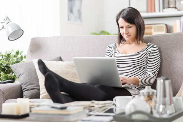 Woman using a laptop at home - Foto, imagen