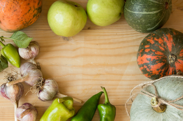 Ernte- oder Erntedankhintergrund mit Herbstfrüchten und Kürbissen auf einem rustikalen Holztisch - Foto, Bild