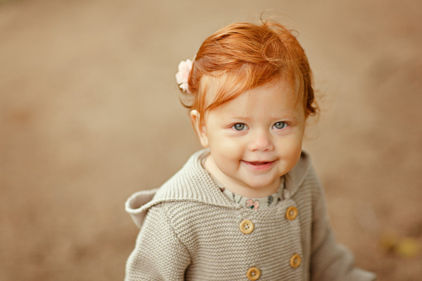 Red-haired baby girl smiling, close-up portrait - Fotó, kép