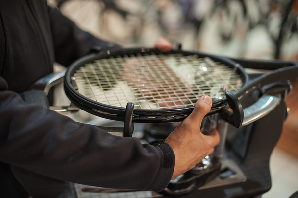 Close up of tennis stringer hands doing racket stringing - Foto, afbeelding