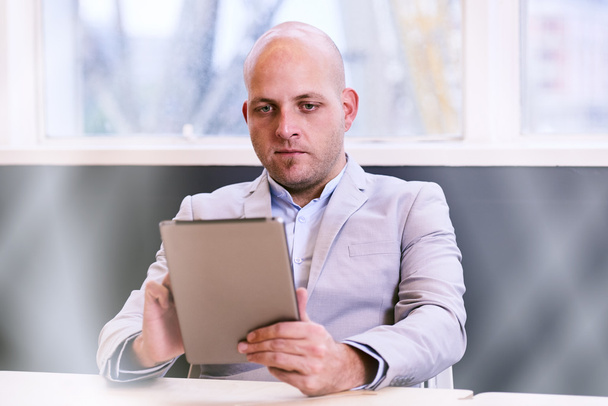 Άνθρωπος των επιχειρήσεων κατέχει και χρησιμοποιώντας ένα tablet υψηλής τεχνολογίας - Φωτογραφία, εικόνα