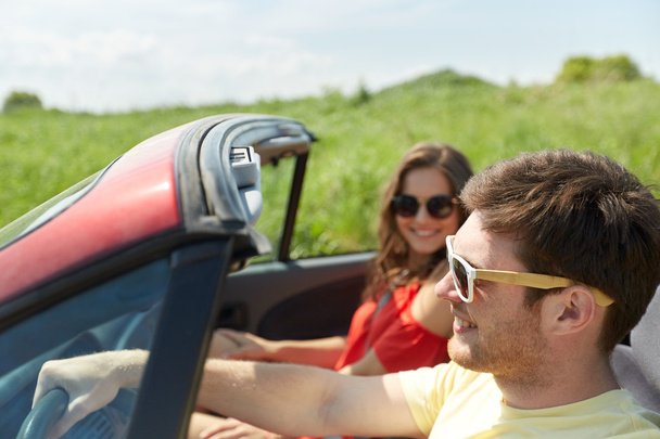 happy couple driving in cabriolet car at country - Foto, Imagen