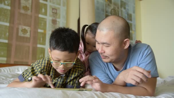 Père et ses enfants regardant sur l'écran de la tablette
  - Séquence, vidéo