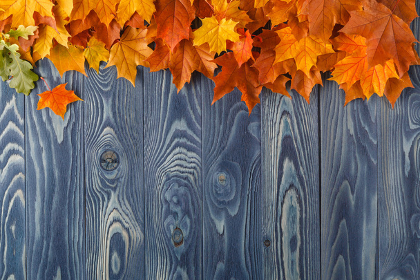 Autumn leaves over old wooden background. With copy space - Photo, Image