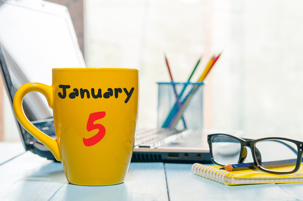 5th Ιανουαρίου. Ημέρα 5 του μήνα, ημερολόγιο σε φλιτζάνι πρωινό καφέ ή τσάι, αρχιτέκτονα φόντο στο χώρο εργασίας. Χειμωνιάτικη ώρα. Κενός χώρος για κείμενο - Φωτογραφία, εικόνα