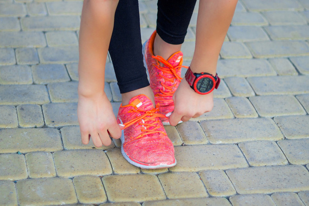 Молода фітнес дівчина зв'язує кросівки мереживами, які готуються до бігу
 - Фото, зображення
