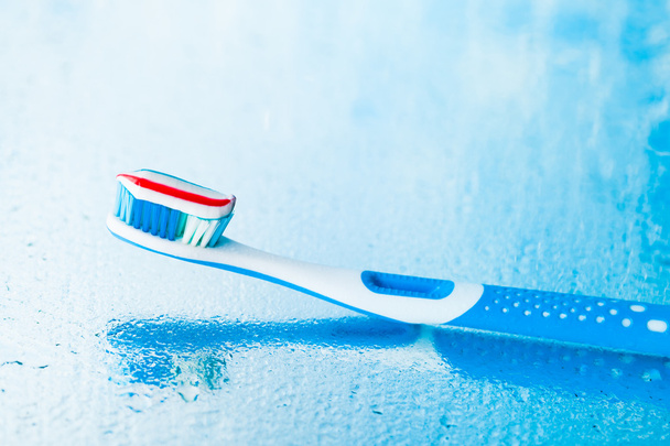 cepillo de dientes con pasta de dientes de rayas rojas
 - Foto, Imagen