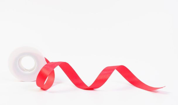 Red ribbon and roll on white background - Φωτογραφία, εικόνα