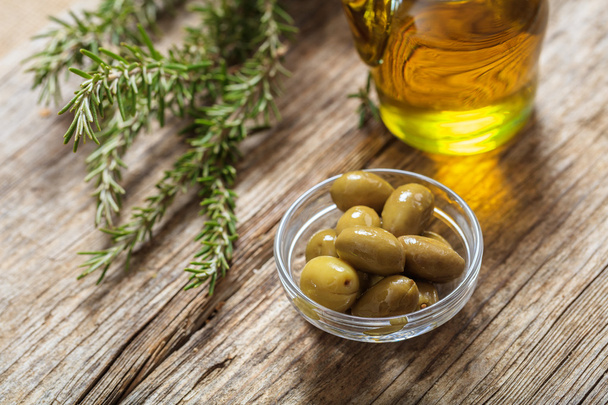 Olives and olive oil on a table - Fotoğraf, Görsel