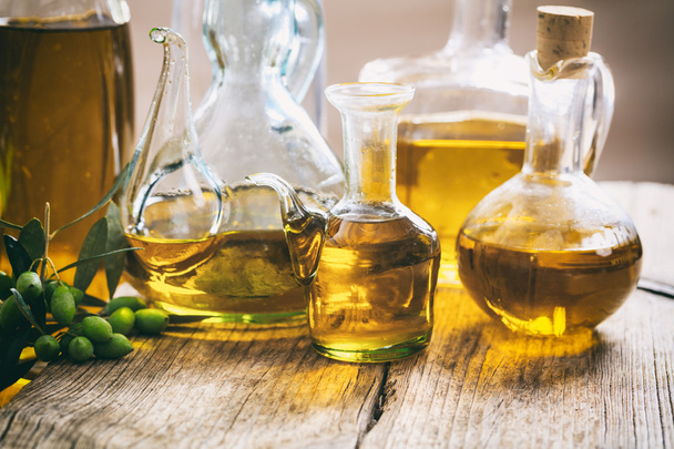Bottles of olive oil on a table - 写真・画像