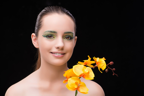 Mooie vrouw in schoonheid concept met orchideebloem - Foto, afbeelding