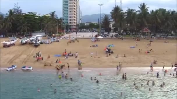 Visitors and travellers are swimming on the beach of a coastal city in asia - Filmagem, Vídeo