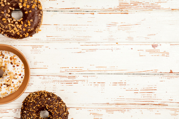 Lekkere donuts op witte houten achtergrond - Foto, afbeelding