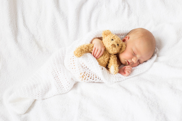 Новорожденный ребенок с плюшевым мишкой
 - Фото, изображение