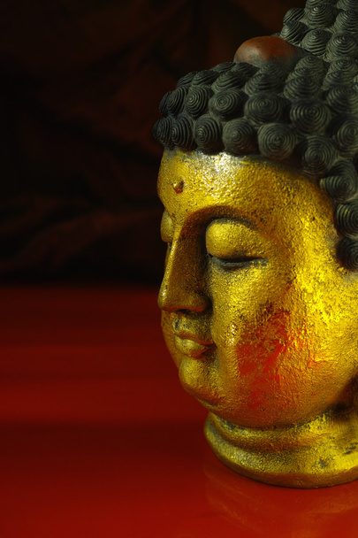 Gold Buddha rosto tranquilo no fundo vermelho escuro, espaço de cópia
 - Foto, Imagem