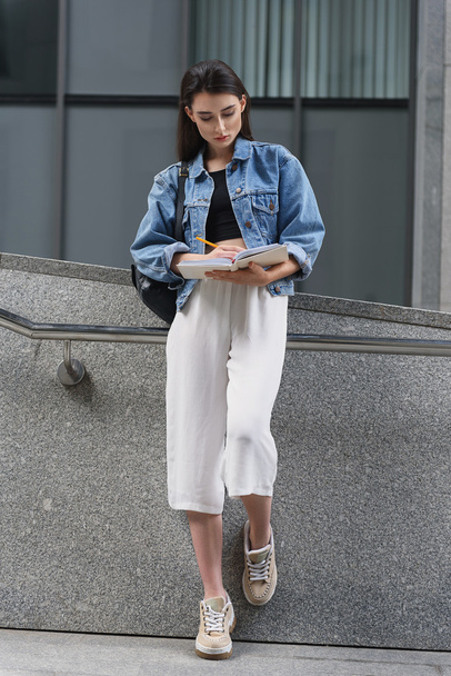 female designer drawing in her diary on the street - Photo, image
