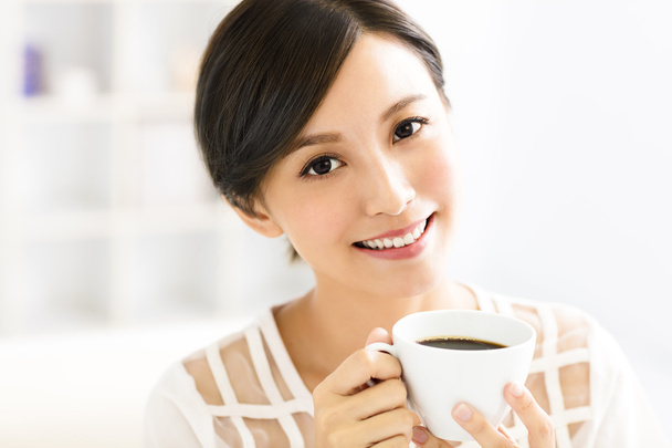 nuori hymyilevä nainen juo kahvia aamulla
 - Valokuva, kuva