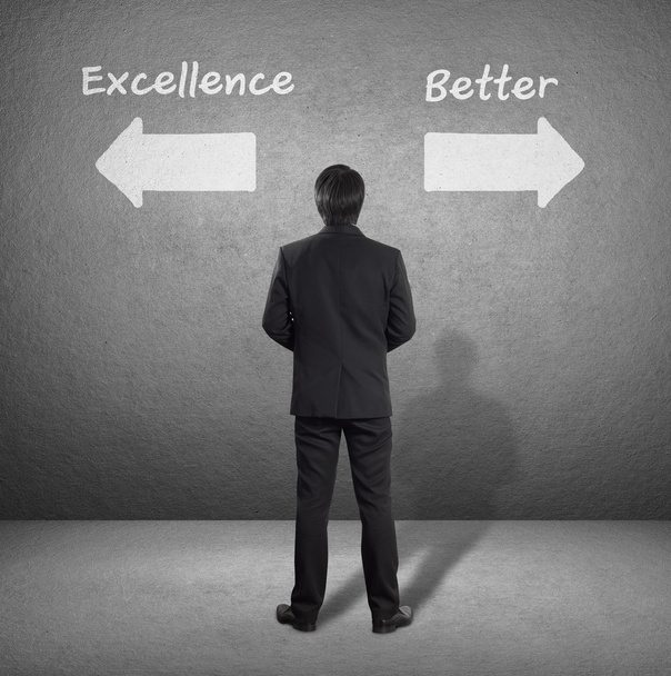 zakenman staande voor twee pijlen tonen twee verschillende richtingen tussen Excellence of beter - Foto, afbeelding