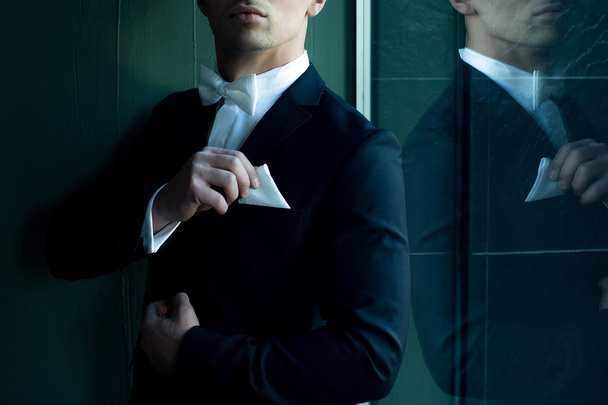 Man in suit touches handkerchief - Zdjęcie, obraz