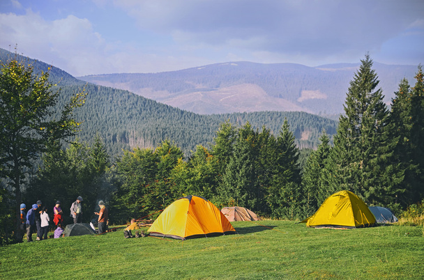 Berglandschap op zon. Toeristische tenten in bos - Foto, afbeelding