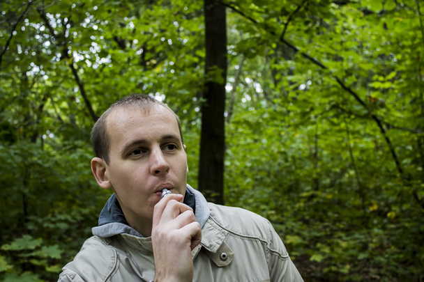 Homem fumando sigarette eletrônico ao ar livre
 - Foto, Imagem