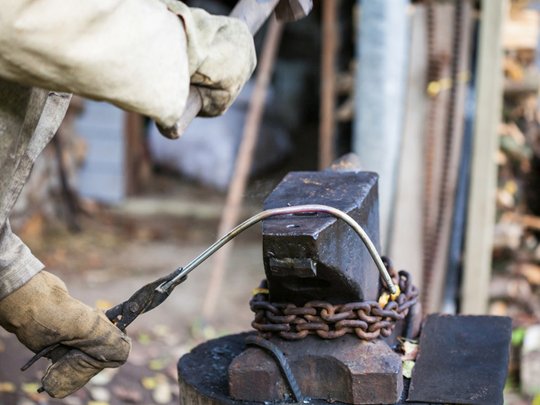 ferreiro forja haste de ferro em uma bigorna
 - Foto, Imagem