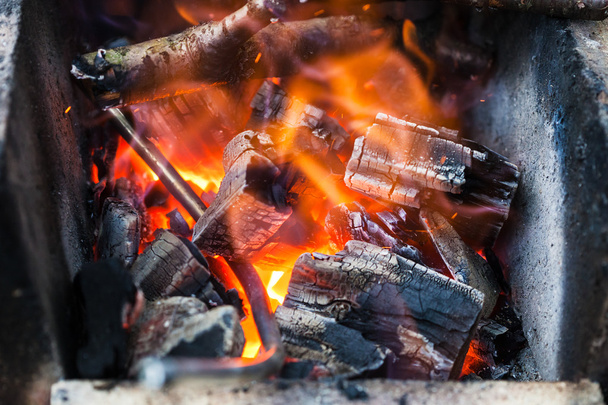 tige de fer est chauffée dans la combustion des charbons en bois
 - Photo, image
