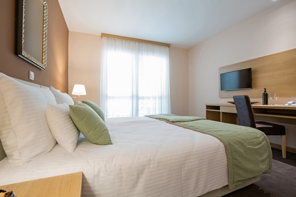 Modern beautiful double bed hotel bedroom interior - Фото, изображение