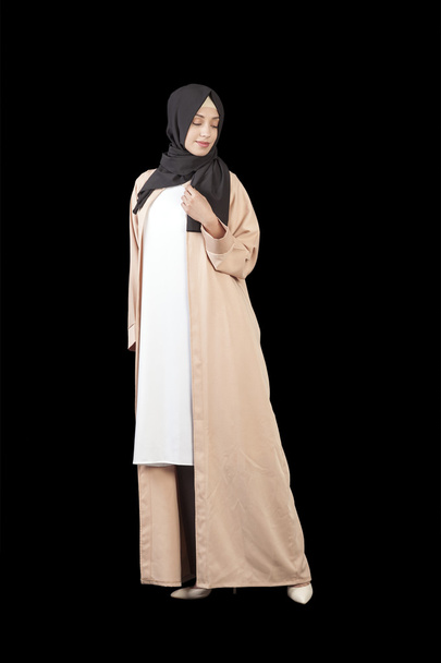 Muslim woman in a beautiful Islamic dress in full growth, isolated on a black background - Foto, afbeelding