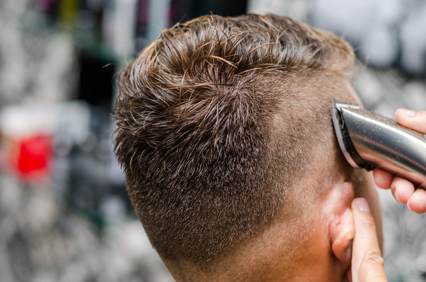 Taglio e modellazione dei capelli da barbiere con trimmer elettrico
 - Foto, immagini