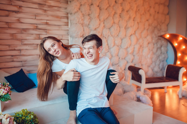 Young couple sitting embracing and having fun at home - Foto, imagen