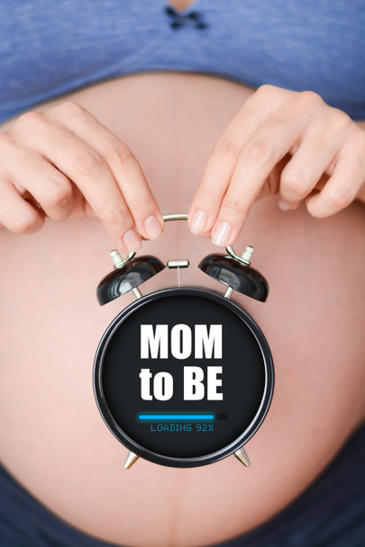 Mujer embarazada sosteniendo reloj - Foto, Imagen