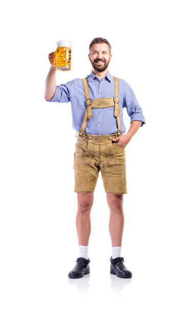 Man in traditional bavarian clothes holding mug of beer - Фото, изображение