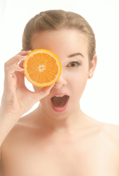 Surprised beautiful woman with a slice of orange - Zdjęcie, obraz