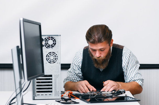 Bearded engineer assembling computer at workplace - Zdjęcie, obraz